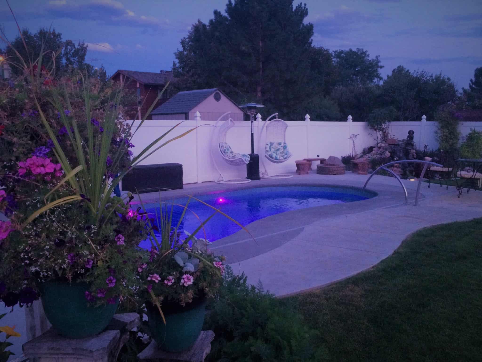 A completed fiberglass pool installation, ready for summer nights by the pool.
