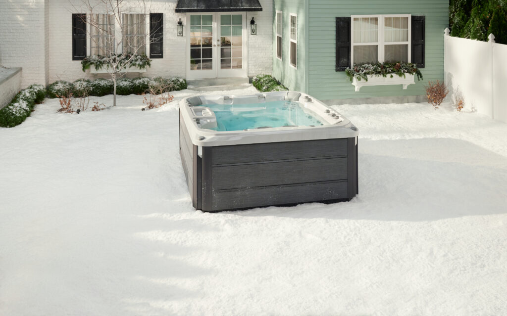 A hot tub sitting in a backyard surrounded by snow.